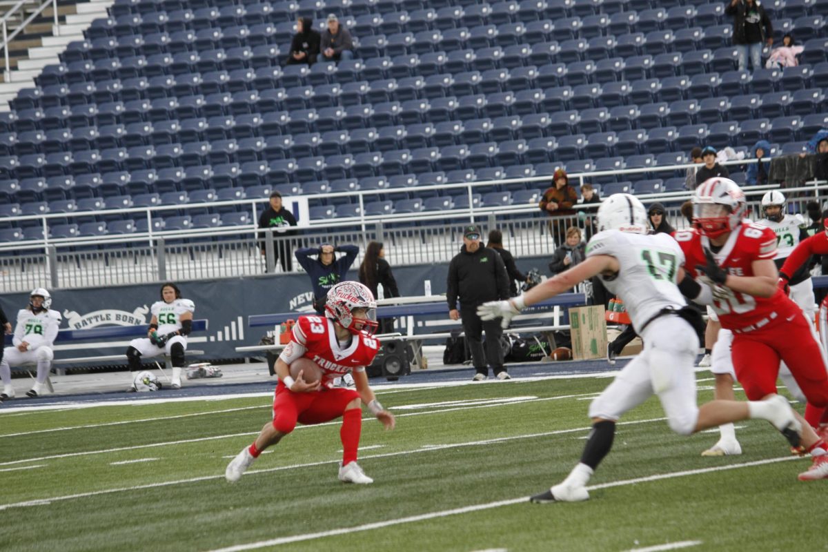 Junior Quarterback Jace Estabrook rushes during Truckees 35-14 state championship victory over SLAM Academy.